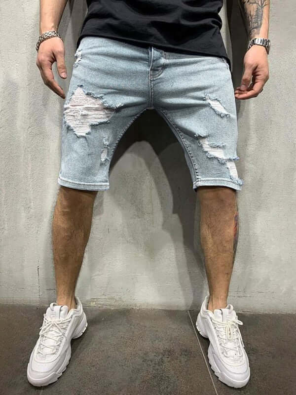 Man wearing Averra Ripped Short Jeans with oversized fit, styled for streetwear fashion and paired with white sneakers.